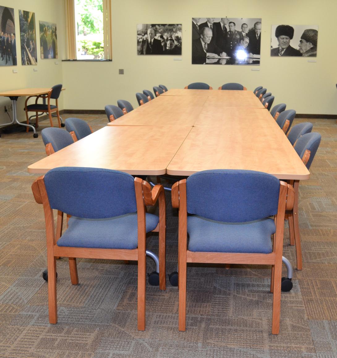 A long row of tables, with chairs along the perimeter are shown