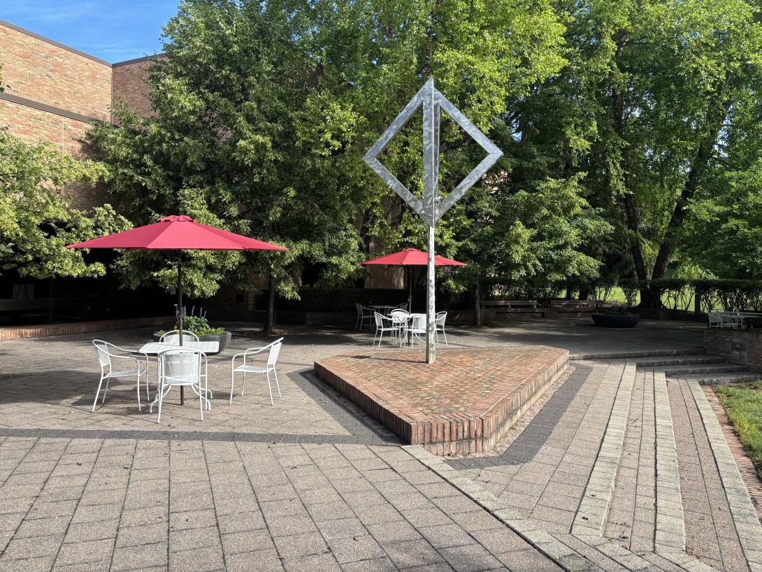 The back patio at the Library, paved with bricks, features art work and furniture.