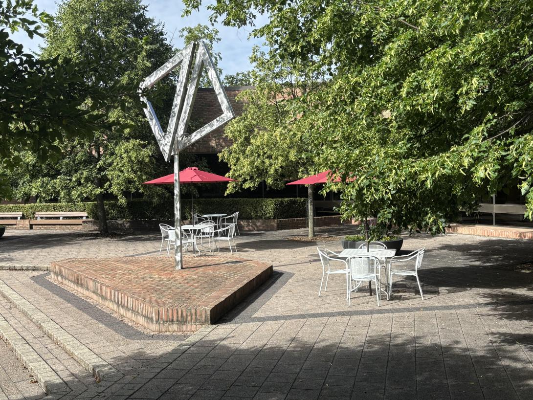 The back patio at the Library, paved with bricks, features art work and furniture.